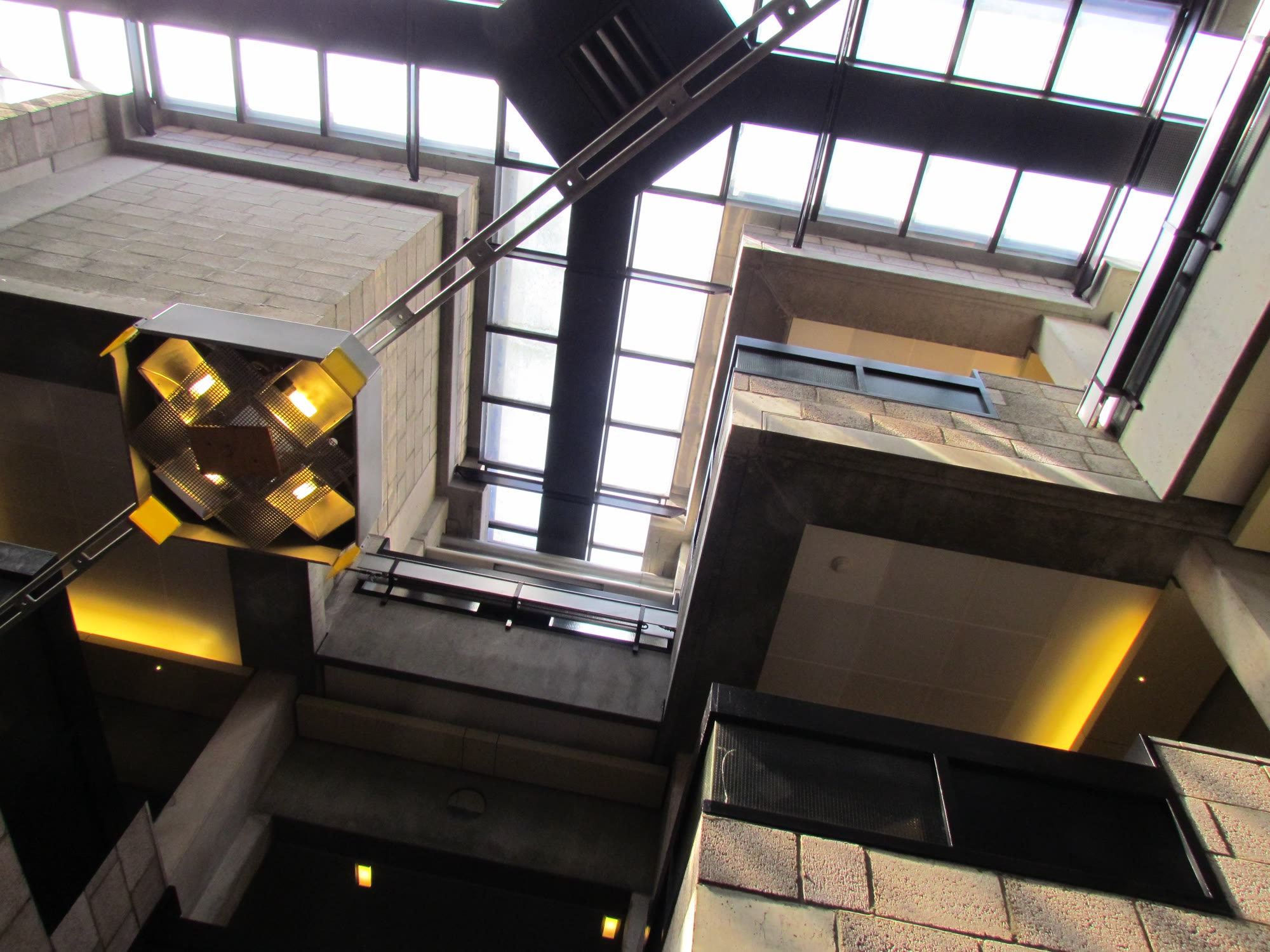 An upward view through the stacked modules at Centraal Beheer. Lacking a traditional central corridor, the building relies entirely on the gaps between work islands to serve as the primary paths for circulation and casual collision.