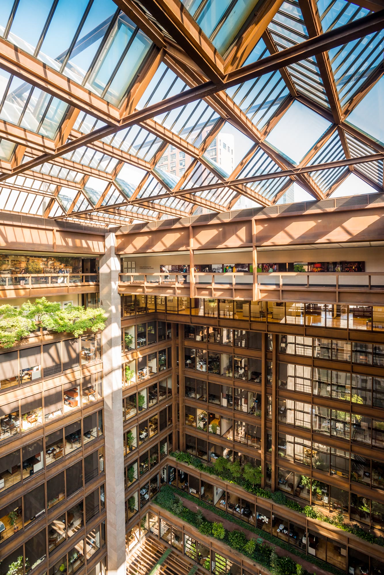 The Ford Foundation headquarters in New York, 1967. The offices wrap around a lushly planted central court encased in glass. Architect Kevin Roche designed this visual permeability to foster a sense of community, ensuring that employees remained constantly aware of their "fellow man" working across the void.