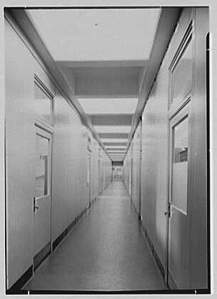 Bell Telephone Laboratories at Murray Hill, New Jersey, in 1942. The deliberate 700-foot length of the physics wing's central corridor forced prolonged circulation. As author Jon Gertner described it in 2012, traveling this "impossibly long tiled corridor" without encountering colleagues and ideas was impossible, which was entirely the point, turning scientists into "magnets rolling past iron filings".
